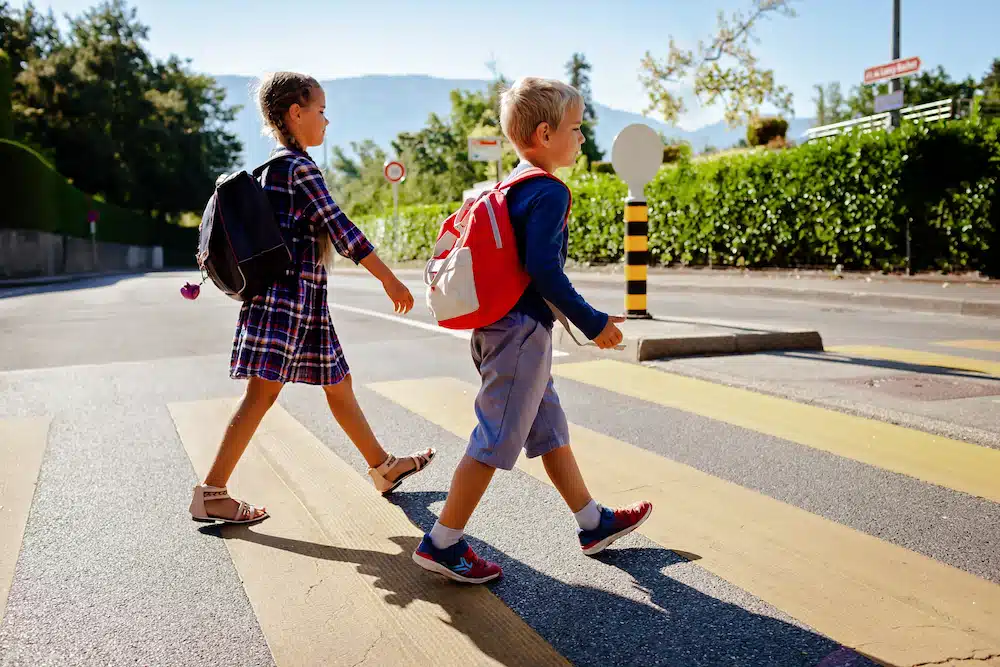 Kids with backpacks crossing the road