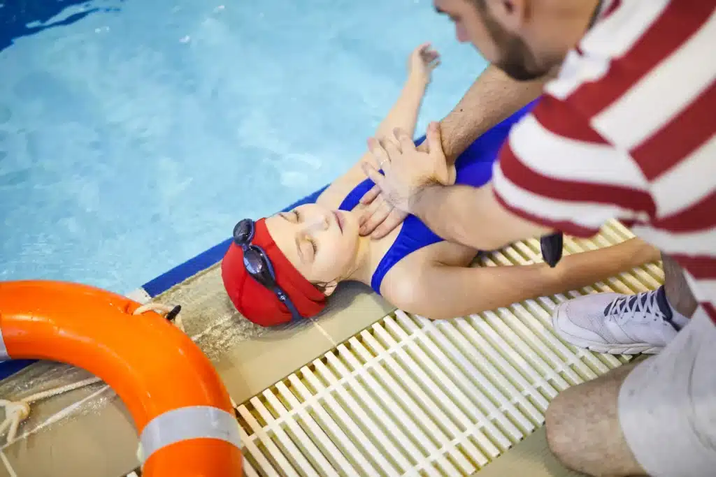 Adult Helping Child at Swimming Pool Side