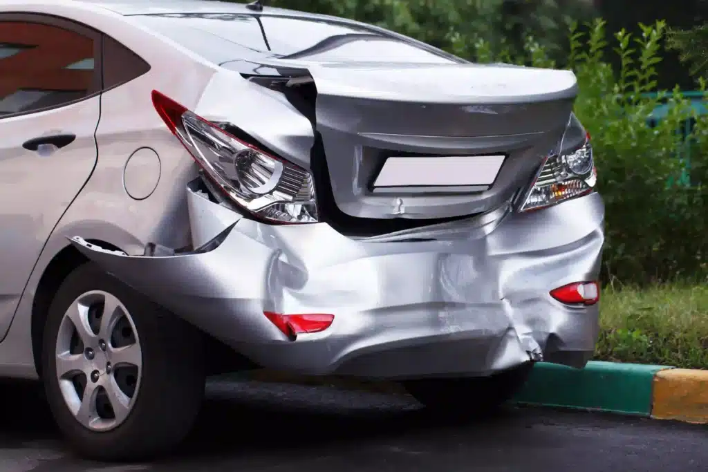 Damaged Silver Car After Accident on City Street