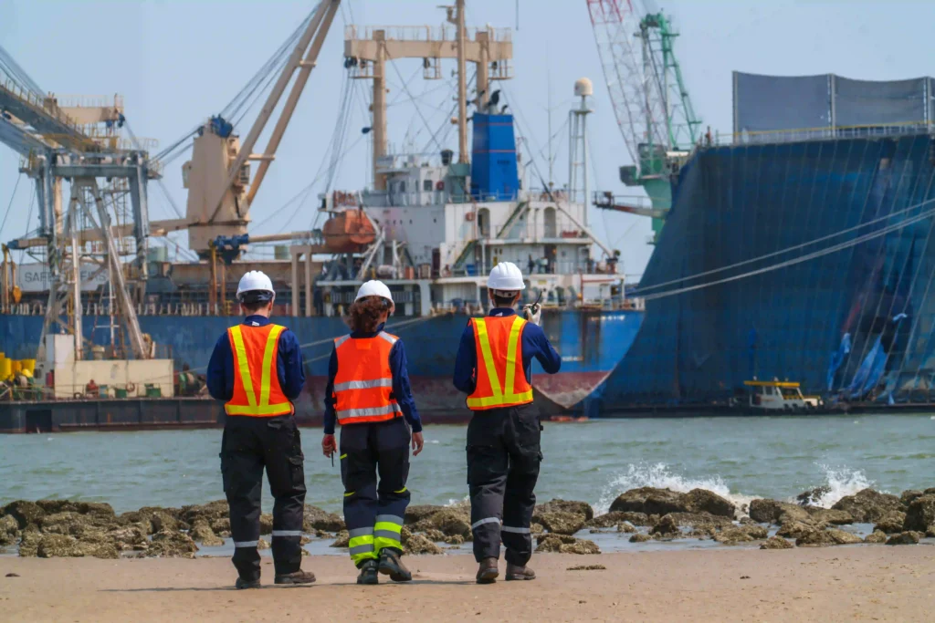 workers-walk-along-the-shore-near-ships-and-machin-