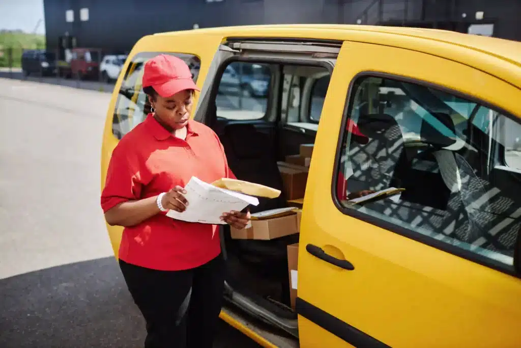 focused DHL woman-delivering-packages-from-a-yellow-truck