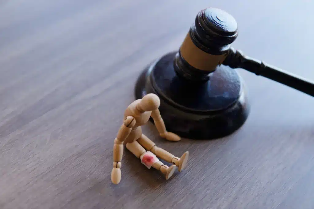 hurt-mannequin-with-gavel-on-wooden-table-