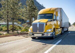 A yellow truck drives down a highway, symbolizing what to do if you’re in an accident with a Penske truck in Louisiana.
