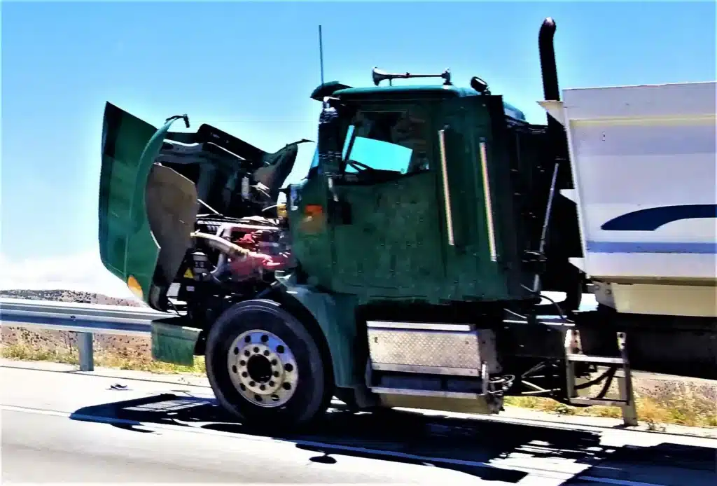 Green Semi-Truck with Hood Open on Highway