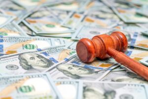 A gavel on top of a stack of money. How much is the typical car accident settlement in New Orleans.