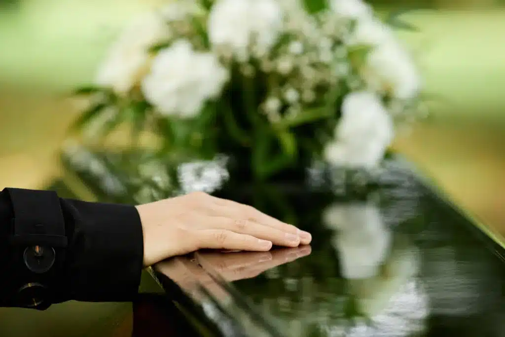 Hand Placed on Casket with Flowers after wrongful death