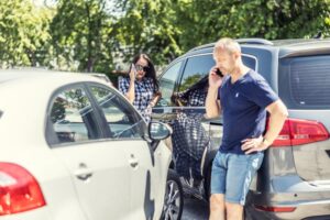 Two people on their phones after a car accident. What are the chances of winning a car accident lawsuit?