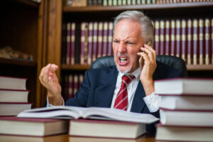 An angry businessman on the phone, firing his personal injury lawyer in Louisiana.