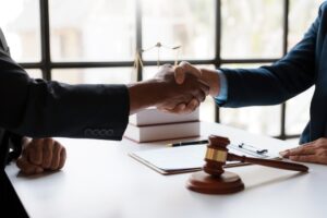 A lawyer shaking hands with a client. Is it worth it to hire personal injury lawyer?