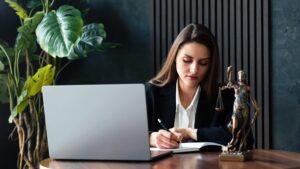 A personal injury lawyer at her desk, writing on a piece of paper. What is a personal injury lawyer?