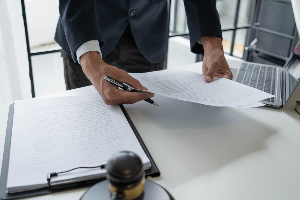 A lawyer looking over papers for a client. When to hire a personal injury lawyer