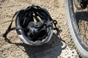 A crashed motorcycle with a helmet on the street. 10 reasons why you need a motorcycle accident lawyer.