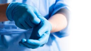 A doctor putting on gloves. Why should you seek medical attention after a car accident even if you feel fine?