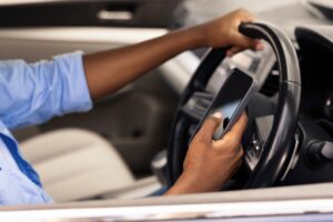 A man texting while driving. How does it contribute to driving accidents?