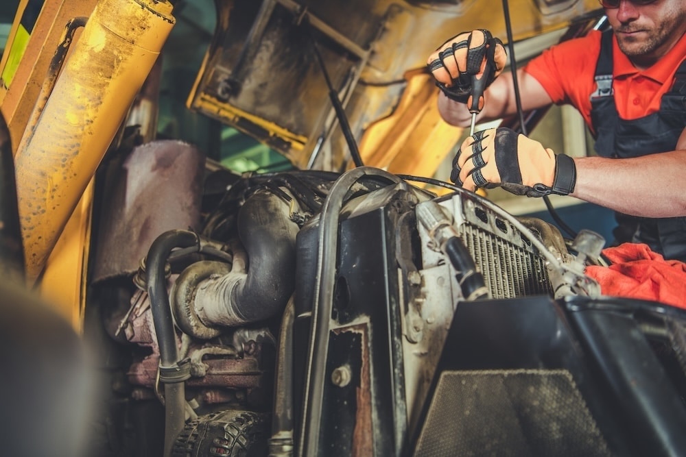 mechanic working on a truck performing maintenance