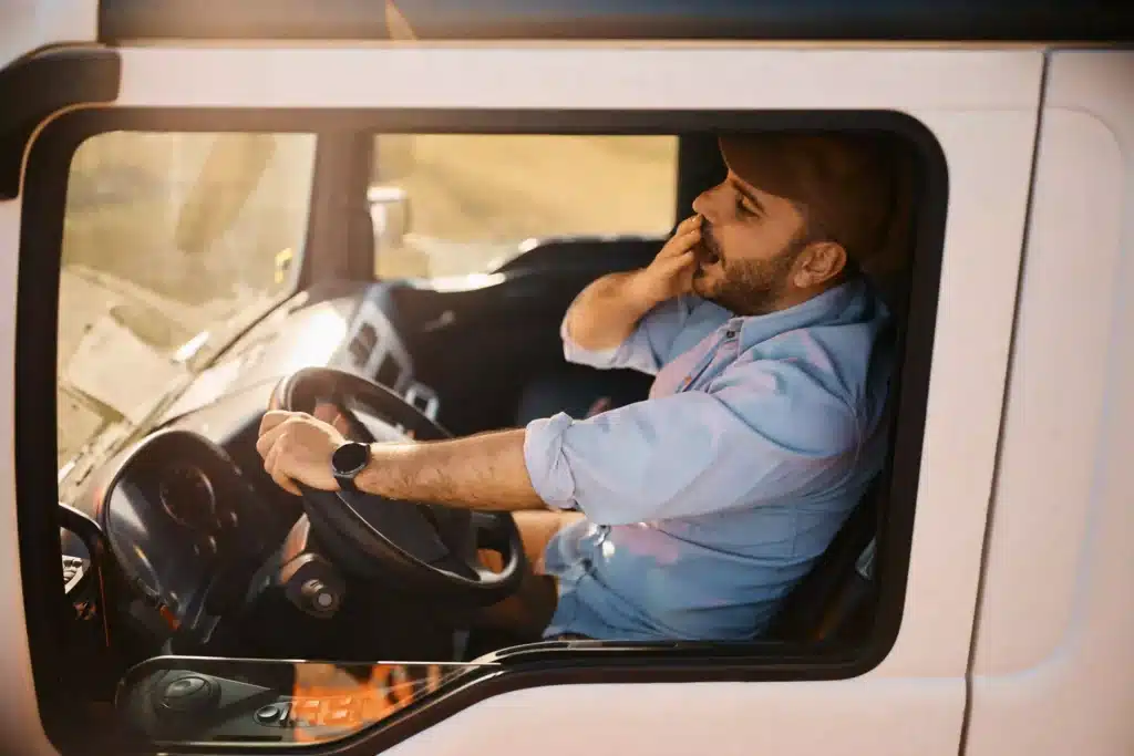 Truck Driver Tired and Yawning Inside Truck