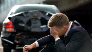 A man covering his face after being partially at fault in a rear-end accident in Louisiana