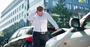 A man rubbing his neck after a rear-end accident in New Orleans, wondering what he should do.