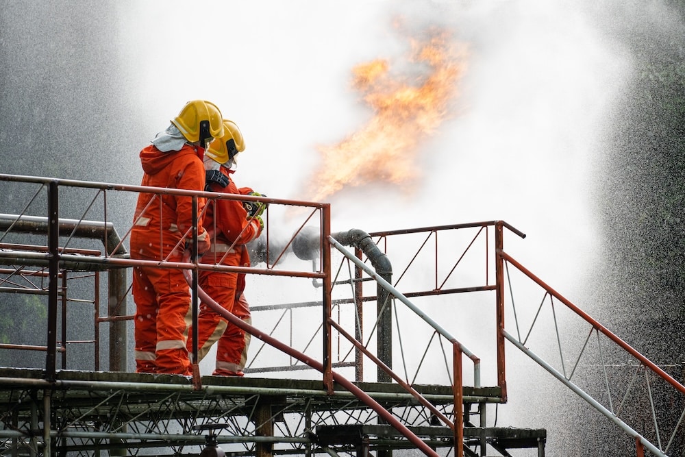 firefighters putting out fire in chemical plant