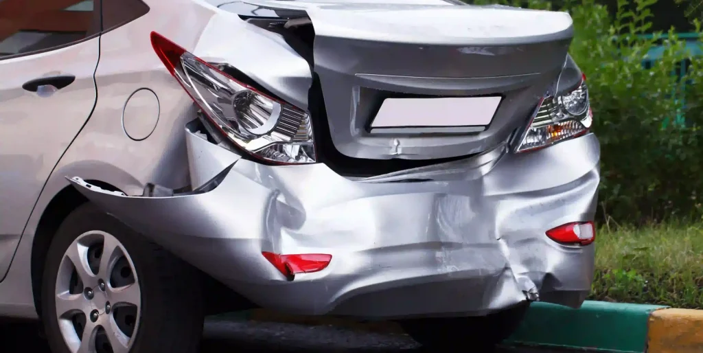 Damaged Silver Car After Accident on City Street