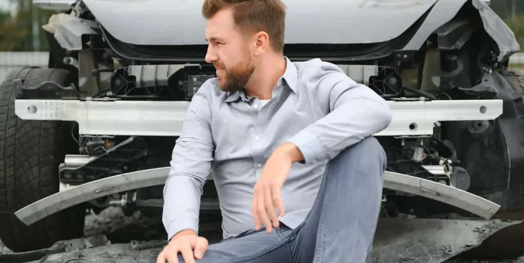 man-sitting-near-wrecked-car-after-accident-2026-03-