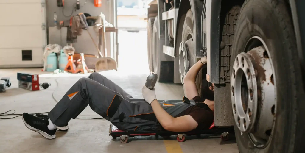 Mechanic Repairs Large Truck in Dusty Garage