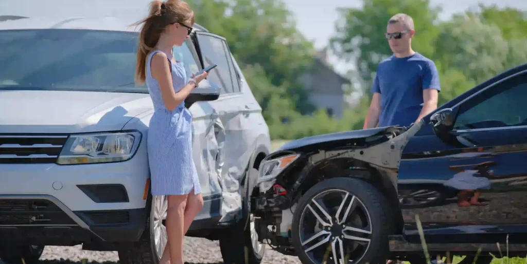 woman-with-damaged-car-talking-on-cellphone-